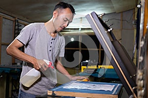 Male worker using sprayer to to paste the paper when going to make a film