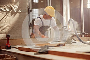 Male worker using wood cutting circular saw machine in workshop