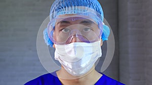 Male worker wear protective gears like latex gloves, face mask, bouffant cap, medical goggle at work