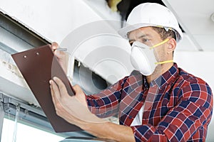 male worker wearing mask writing notes