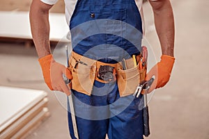 Male worker wearing tool belt with building instruments