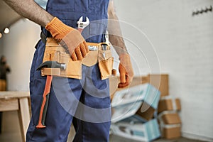 Male worker wearing tool belt with instruments