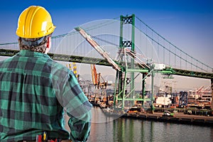 Male Worker Wearing Yellow Hard Hat Overlooking the San Pedro Ship Yard and Bridge