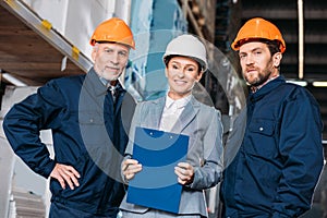 male workers and female inspector in helmets