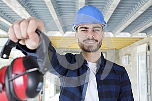 male working proffering ear defenders