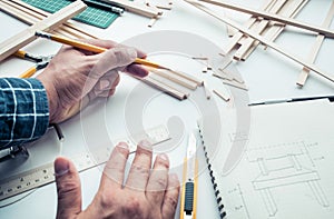 Male working on worktable with balsa wood material.