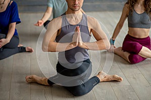 Male yoga instructor taking yoga class in fitness studio