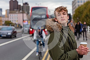 Male Young Adult Teenager Drinking Coffee by Red London Bus