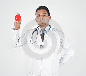 Male young doctor showing a red apple