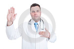 Male young doctor swearing or having the Hippocratic oath photo