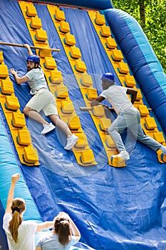 Males climbing on inflatable slide