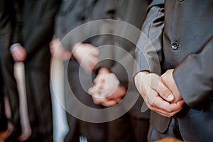 Males Standing in Line. Focus on Hands.