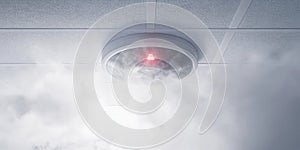 Malfunctioning Sensor With Red Light, Smoke Detector with Smoke on White Ceiling. Fire Alarm