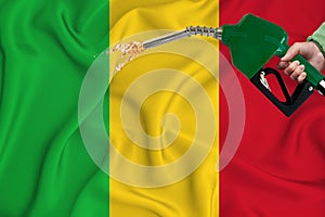 MALI flag Close-up shot on waving background texture with Fuel pump nozzle in hand. The concept of design solutions. 3d rendering