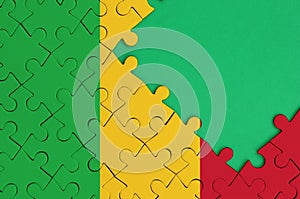 Mali flag is depicted on a completed jigsaw puzzle with free green copy space on the right side