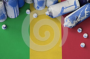 Mali flag and few used aerosol spray cans for graffiti painting. Street art culture concept