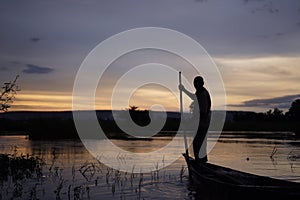 Malian Fisherman Manouevring His Boat Along The Niger Riverside AT Sunset