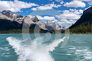 Maligne Lake as seen from the water, on a sunny summer day in Jasper National Park Canada, with boat wake in photo