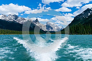 Maligne Lake as seen from the water, on a sunny summer day in Jasper National Park Canada, with boat wake in photo