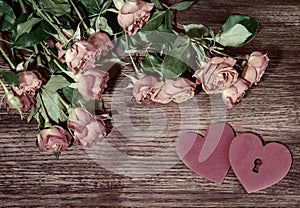 Mall pink garden roses and hearts on wooden surface. Retro style romantic floral background. Valentines day background.