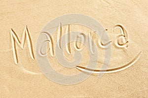 Mallorca handwritten in golden beach sand photo