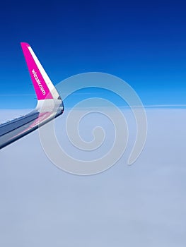 Malmo, Sweden - August 22, 2022: Left wing of WizzAir airplane after taking off above Malmo Sturup airport heading to Belgrade,