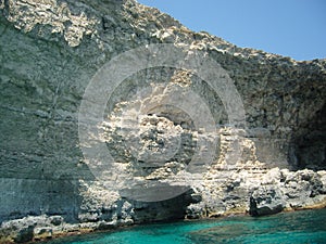 Malta steep coastal line made of limestone with plenty of caves with visible geomorphological layers