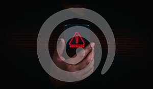 Malware concept. Red malware icon alert on futuristic transparent smart mobile phone in businessman hand on dark background.