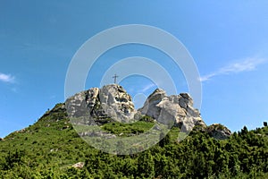Maly Giewont mountain with a cross on the top surrounded by greenery
