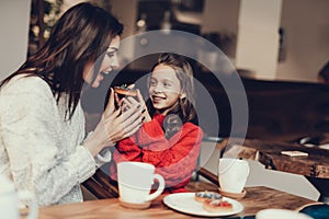 Mama and daughter heaving breakfast in cafe