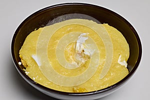 (Mamaliga) with cheese, eggs, and cream