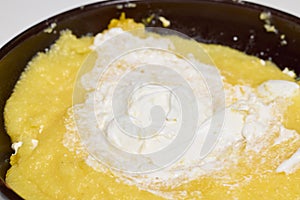 (Mamaliga) with cheese, eggs, and cream