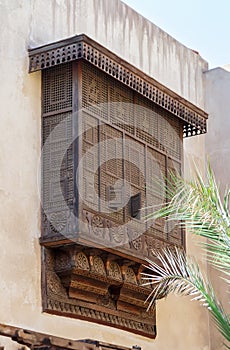 Mamluk era style oriel window covered by interleaved wooden grid - Mashrabiya - on stone wall, Cairo, Egypt photo