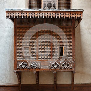 Mamluk era style oriel window covered by interleaved wooden grid Mashrabiya on stone wall, Cairo, Egypt photo