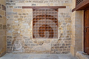 Mamluk era wooden closed window with wooden ornate grid over stone bricks wall, Medieval Cairo, Egypt photo