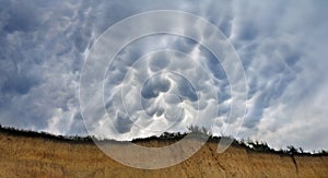 Mammatus unusual clouds  marsupial, called Mastoid, umeshaped  on sky over over the cliff photo