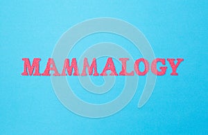 Mammology word in red letters on a blue background. Concept is a section of medicine dealing with the treatment and prevention of