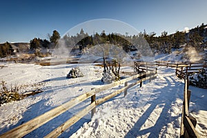 Mammoth Hot Springs trail with steamy terraces during winter snowy season in Yellowstone National Park, Wyoming photo