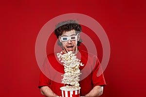 man in 3d glasses, red t-shirt jumping with big bucket of popcorn