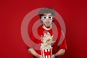 man in 3d glasses, red t-shirt jumping with big bucket of popcorn