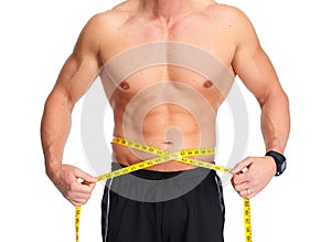 Man abdomen with measuring tape over blue background.