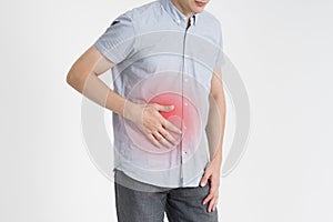 Man with abdominal pain, stomach ache on gray background photo