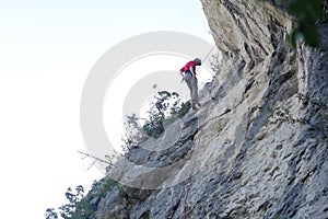 Man is abseiling on a rock wall