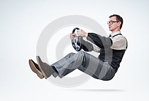 Man accountant with glasses and sleeves is driving a car with steering wheel. Driver concept