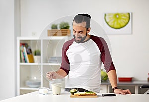 Man adding sugar to cup for breakfast at home