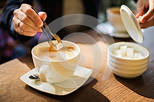 Man adding sugar to his coffee