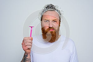 Man adjust the beard with a razor blade