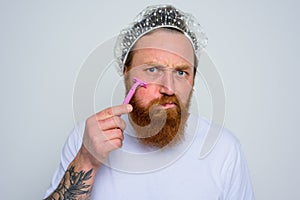 Man adjust the beard with a razor blade