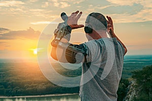 Man with adjustable articulated elbow orthosis on top cliff at sunset