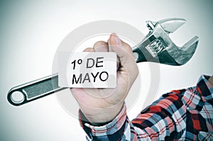 Man with adjustable wrench and signboard with text 1o de mayo, m